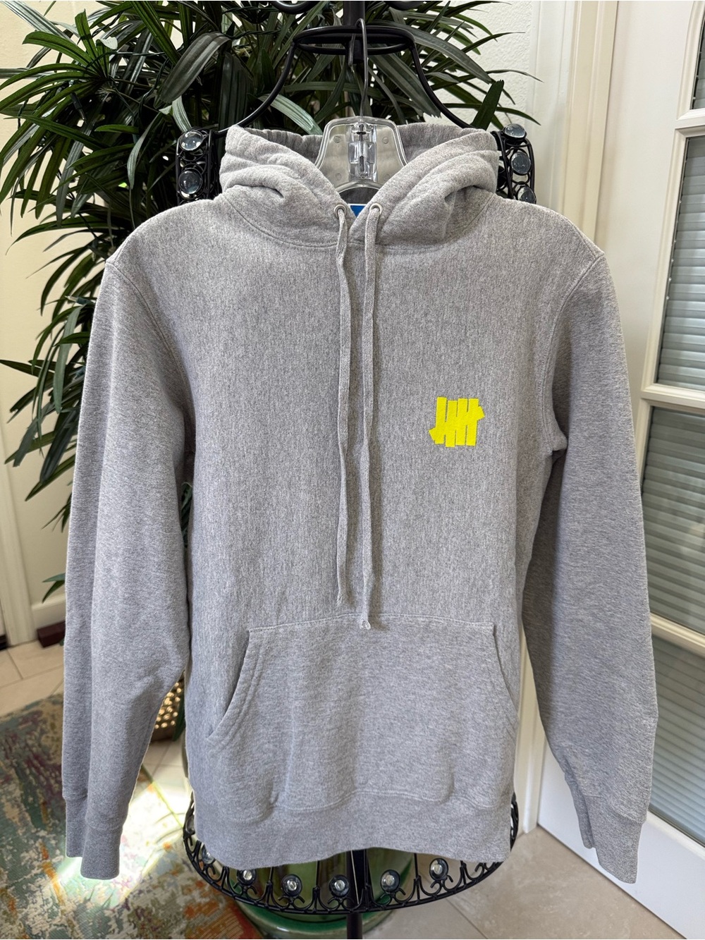 Gray Undefeated Hoodie with Striking Yellow Undefeated Logo.